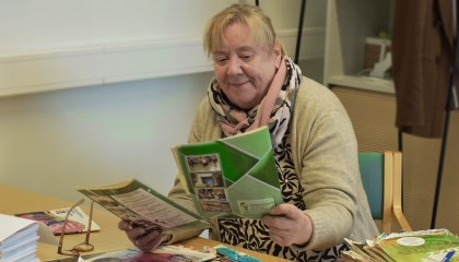 Henkilö tutkii pöydällä olevia vanhoja opinto-oppaita.