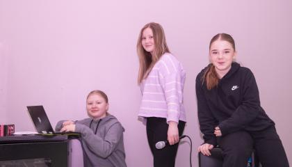 Kolme lasta, vasemmanpuoleisin on kannettavan tietokoneen ääressä.