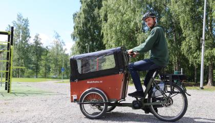 Henkilö ajaa puistossa laatikkopyörällä. 