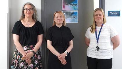 Kolme naista seisoo rinnakkain katse kohti kuvaajaa. 