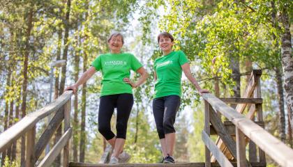 Iloisia naisia portailla metsän keskellä.