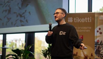 Shein Shapiro seisoo esiintymislavalla mikrofoni kädessään.