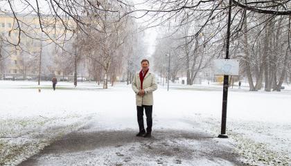 Henkilö seisoo lumisessa maisemassa.