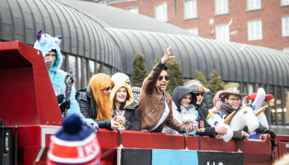 Lukion päättäviä iloisia opiskelijoita kuorma-auton lavalla