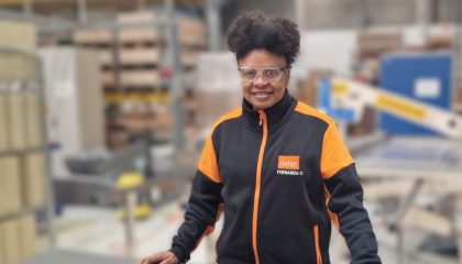 Henkilö hymyilemässä varastohuoneessa.