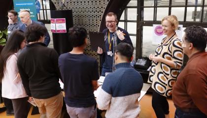 Englanninkielisen asukasillan osallistujia kokoontuneena pöydän ääreen keskustelemaan kaupungin edustajien kanssa.