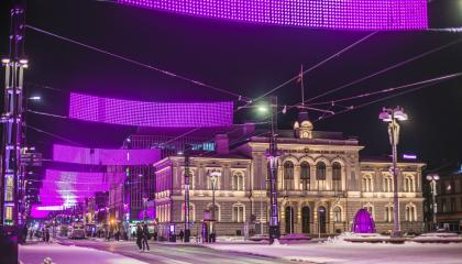 Tampereen Raatihuone ilta-aikaan. Hämeenkadun valoverhot valaistu violetilla värillä.