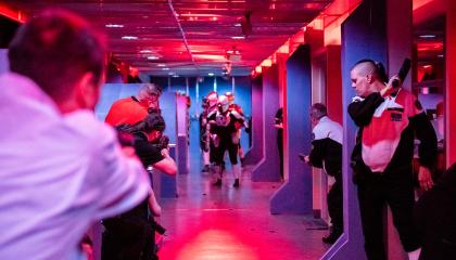 Punaiseksi valaistussa käytävässä ihmisiä pelaamassa liveroolipeliä. 