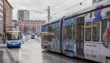 Bussi ja ratikka ajavat kadulla.