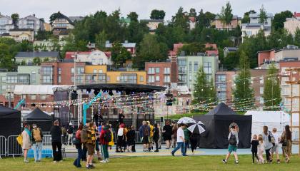 Festivaalimaisema, jonka takana kohoaa Pispalan rinteet. 