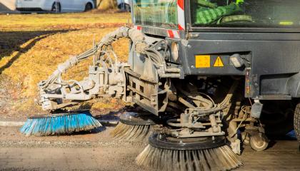 Harjaustraktori puhdistaa katua.