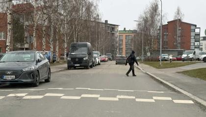 Katu ja kerrostaloja, jalankulkija, autoliikenteen hidaste.