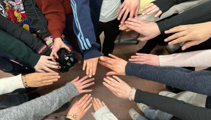 Paljon käsiä koottuna yhteen yhteistyön merkiksi.