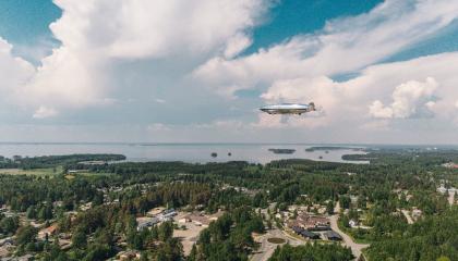 Ilmalaiva kelluu Joensuun keskustan yllä.