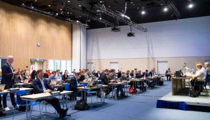 Kaupunginvaltuutetut istuvat pulpeteissaan isossa salissa ja heidän edessään istuu puheenjohtaja.