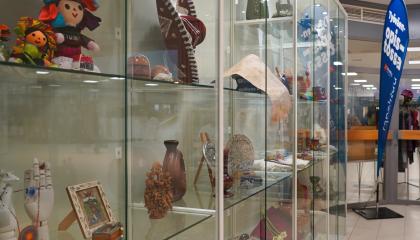 Näyttelyvitriini, jossa on käsitöitä lasin takana.