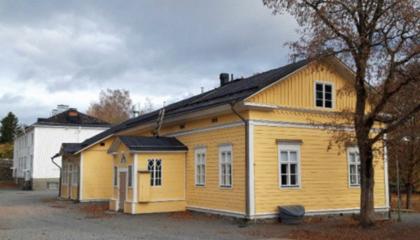 Keltainen puurakenteinen koulurakennus.