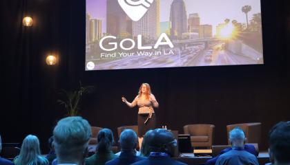 Nainen pitää puhetta tapahtumalavalla.