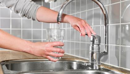 Ihminen laskee hanasta vettä lasiinsa.