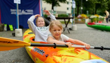 Kaksi lasta kokeilevat melontaa kuivalla maalla.