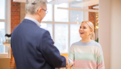 Nuori henkilö kättelee vanhempaa henkilöä.