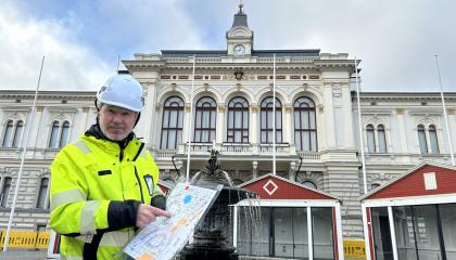 Joulutorin tuottaja Rami Lehtinen osoittaa Joulutorin aluekarttaa. Taustalla rakentuva Joulutori.