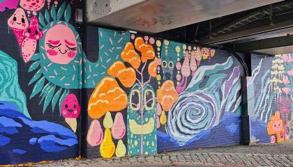 Värikäs taideseinä sillan alla.
