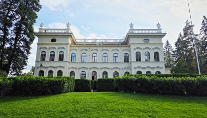 Museo Milavida kuvattuna Näsijärven puolelta. Vaalea kolme kerroksinen kivirakennus, edustalla vihreitä pensaita ja nurmikkoa. 