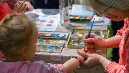 Ikäihminen maalaa lapsen kanssa