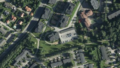 Ilmakuvassa paljon vihreää ja puita, taloja ja katuja.