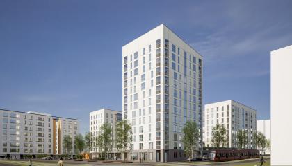 Kuvassa kerrostaloja, torni keskellä, puita.