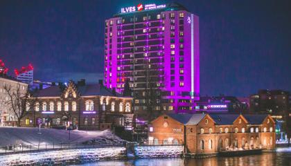 Hotelli Ilves kuvattuna iltaaikaan Hämeensillalta violetiksi valaistuna.