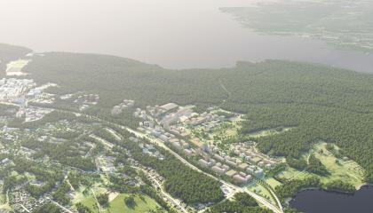 Laaja ilmakuva, jossa takana järvi ja uusi asuinalue keskellä.