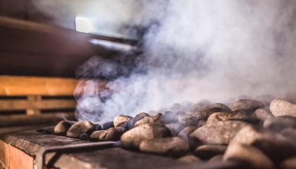 Saunan kiukaan kivet höyryävät.