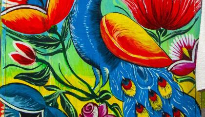 Sini- ja punasävyinen maalaus riikinkukosta.