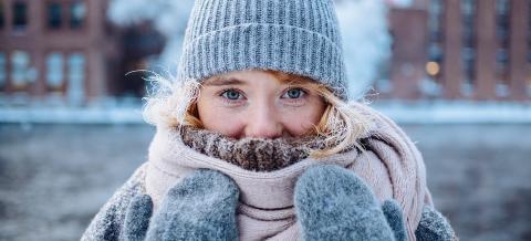 Pipopäinen tyttö jäisen Tammerkosken edustalla.