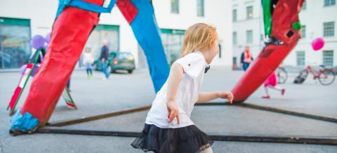 A kid running next to a colourful street art work.