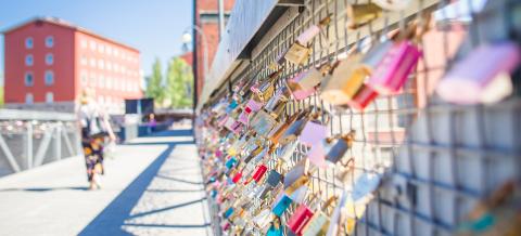 Bridge railing filled with colourful padlocks.