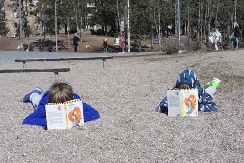 Koululaisia lukemassa ulkona