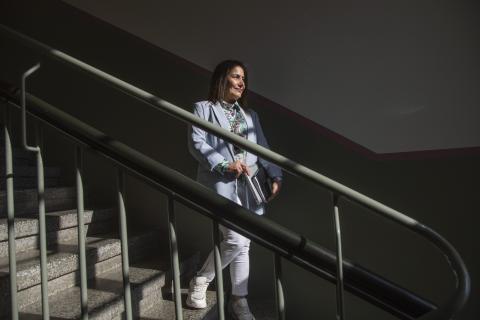 Monikielinen neuvoja poseeraa metalliportaissa.