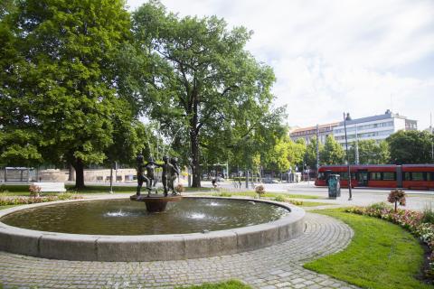 Suihkulähde Pyynikin kirkkopuistossa, taustalla ratikka.