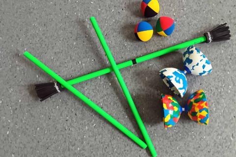 Sirkusvälineitä: heittokepit, värikkäät jongleerauspallot ja värikkäät diabolot.
