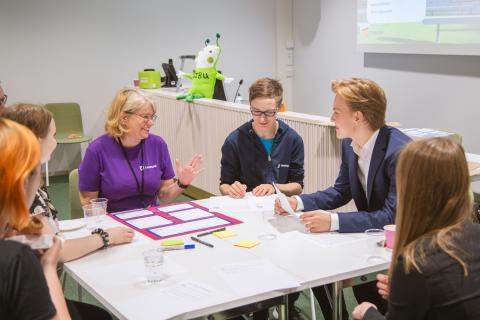 Ihmisiä pöydän ympärillä.