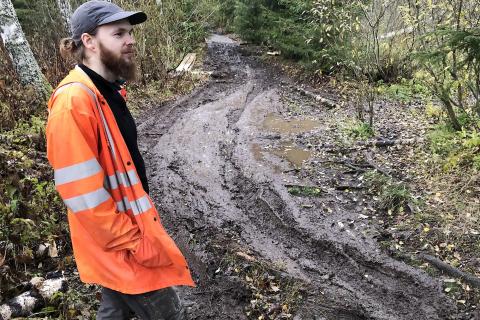 Henkilö seisoo mutaisen polun varrella.