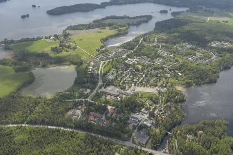 Metsää, peltoa, järviä ja rakennuksia lomittain Kämmenniemen ilmakuvassa.