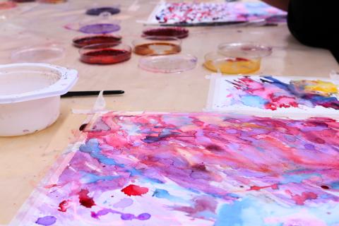 Luonnonväreillä maalattuja töitä pöydällä.