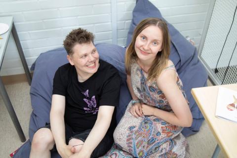 Kaksi henkilöä istuvat säkkituoleilla ja hymyilevät.