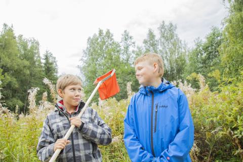 Two boys smiling outside.