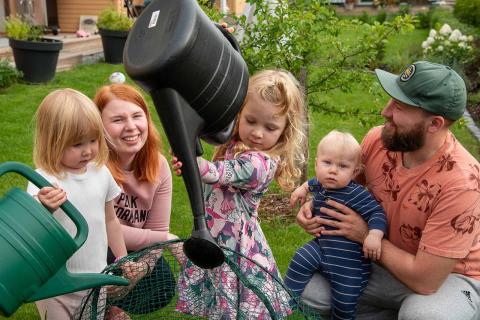 The Lyly family in their miniature garden, Hilla and Pihla with watering cans.