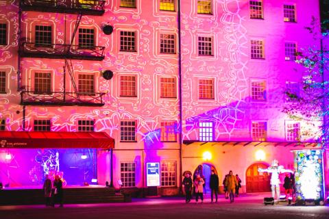 Valotaidetta hämärällä kerrostalojen sisäpihalla. 